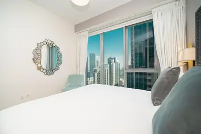 a bedroom with a large window with a city view at BellaVista - Sophisticated - 2 BR - 29 Boulevard - Burj Khalifa & Fountain View in Dubai