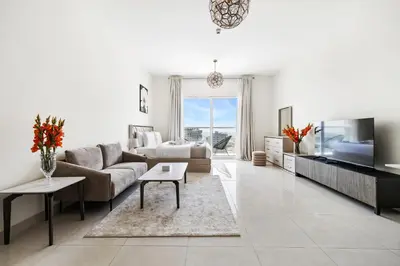 a living room with a couch and a tv at Unlock Metropolis Business Bay in Dubai