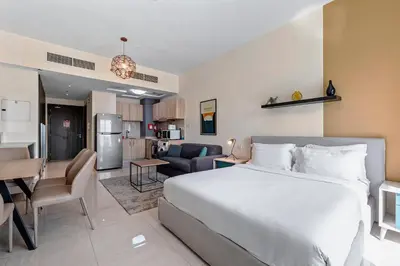 a hotel room with a bed and a kitchen at Unlock Metropolis Business Bay in Dubai