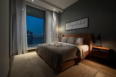 a bedroom with a bed and a large window at Unlock J One Downtown Dubai in Dubai