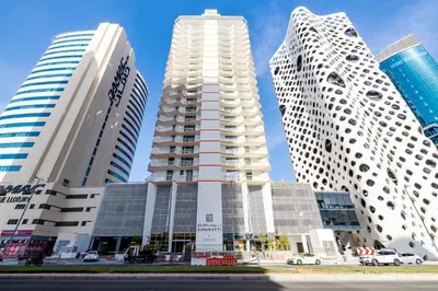 three tall buildings in a city with a blue sky at Unlock Waters Edge in Dubai
