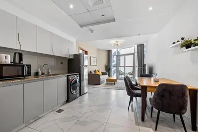 a kitchen and dining room with a table and chairs at Unlock Waters Edge in Dubai