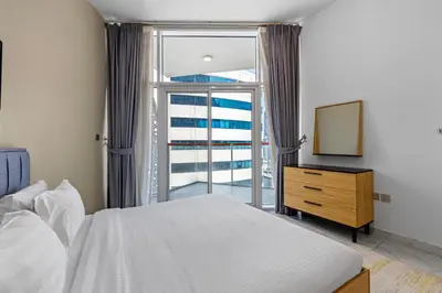 a bedroom with a bed and a large window at Unlock Waters Edge in Dubai
