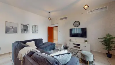 a living room with a couch and a tv at MP12 - Luxurious 2BR in Marina Pinnacle Tower in Dubai
