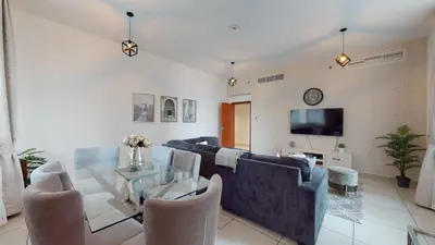 a living room with a couch and a table with chairs at MP12 - Luxurious 2BR in Marina Pinnacle Tower in Dubai
