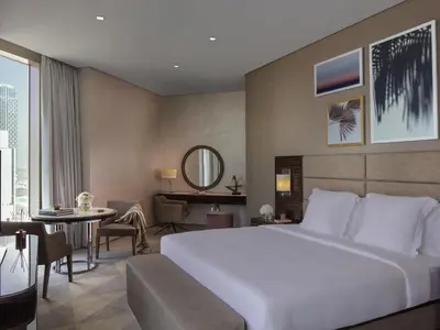 a hotel room with a large bed and a table at Hyde Hotel Dubai in Dubai