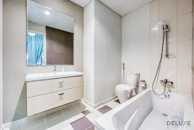 a bathroom with a tub and a sink and a toilet at Extensive 3BR Townhouse at Janusia Damac Hills 2 by Deluxe Holiday Homes in Dubai