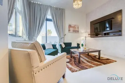 a living room with a couch and a table at Extensive 3BR Townhouse at Janusia Damac Hills 2 by Deluxe Holiday Homes in Dubai