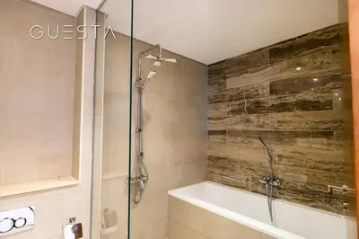 a bathroom with a shower and a bath tub at Azizi Mina The Palm, Free beach and pool access in Dubai