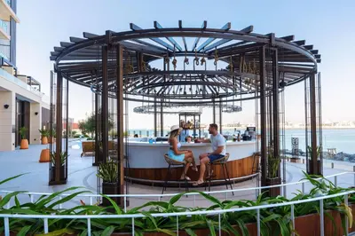 a man and woman sitting at a bar on a building at Hyatt Centric Jumeirah Dubai in Dubai