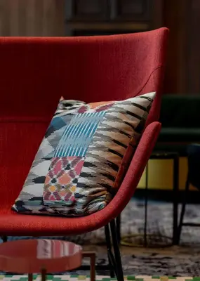 a red chair with a pillow on top of it at Hyatt Centric Jumeirah Dubai in Dubai