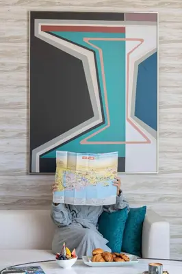 a person sitting on a couch holding a map at Hyatt Centric Jumeirah Dubai in Dubai