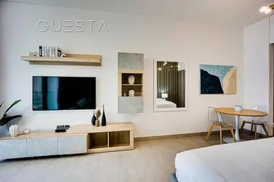 a white room with a bed and a tv and a table at LIV Residence, Dubai Marina in Dubai