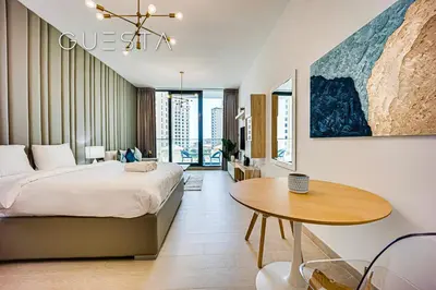 a bedroom with a large bed and a wooden table at LIV Residence, Dubai Marina in Dubai