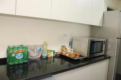 a kitchen counter with a microwave and some food at Smart Living Villa in Dubai