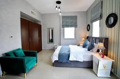 a bedroom with a large bed and a green chair at Dubai marina , Success Luxury apartments, near JBR beach and metro station-daily free housekeeping included in Dubai