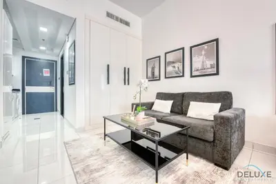 a living room with a couch and a table at Radiant Studio at Giovanni Boutique Suites DSC by Deluxe Holiday Homes in Dubai