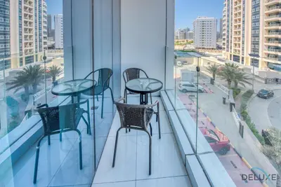 two tables and chairs on a balcony with a view of a city at Radiant Studio at Giovanni Boutique Suites DSC by Deluxe Holiday Homes in Dubai