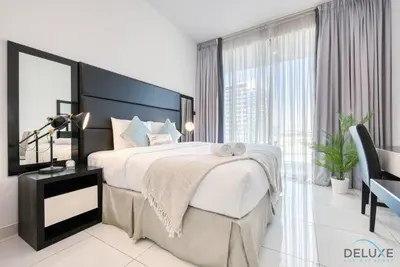 a bedroom with a large bed and a large window at Radiant Studio at Giovanni Boutique Suites DSC by Deluxe Holiday Homes in Dubai