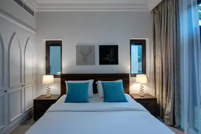a bedroom with a large bed with blue pillows at Durrani Homes - Arabian luxury at Souk Al Bahar besides Burj Khalifa & Dubai Mall in Dubai