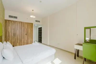 a bedroom with a white bed and a desk at RH- Convenient 1BR, Central, Walk to Mall of Emirates, Al Barsha1 in Dubai