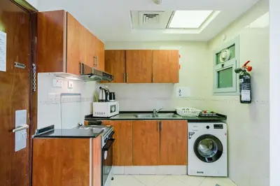a kitchen with a washing machine and a washer at RH- Convenient 1BR, Central, Walk to Mall of Emirates, Al Barsha1 in Dubai