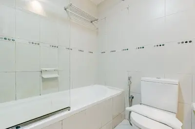 a white bathroom with a tub and a toilet at RH- Modern Urban Oasis, Spacious 02RB near mall of Emirates in Dubai