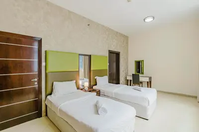 a hotel room with two beds and a desk at RH- Modern Urban Oasis, Spacious 02RB near mall of Emirates in Dubai