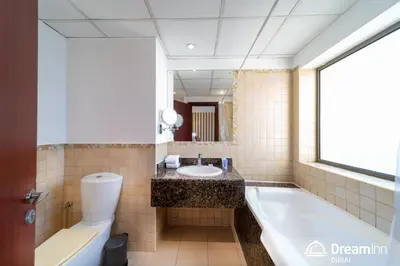 a bathroom with a tub and a sink and a toilet at Dream Inn Apartments - Rimal JBR in Dubai