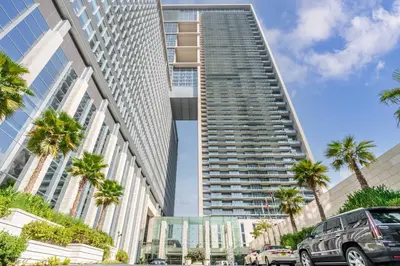 a tall building with palm trees in front of it at Silkhaus newly furnished modern DIFC studio with balcony in Dubai