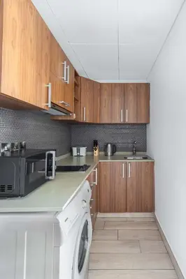a kitchen with wooden cabinets and a dishwasher at Silkhaus newly furnished modern DIFC studio with balcony in Dubai