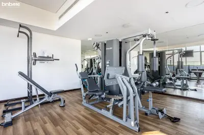 a gym with treadmills and machines in a room at bnbmehomes - The Medalist in Dubai