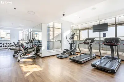 a gym with several treadmills and cardio machines at bnbmehomes - The Medalist in Dubai