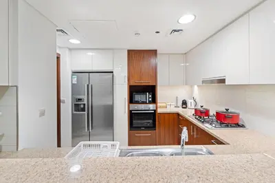 a large kitchen with a stainless steel refrigerator at Luxury 2BR Skyline Sea View Direct Mall Metro Dining Shops City Walk in Dubai