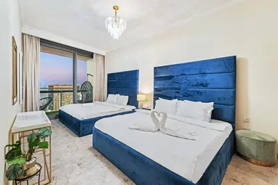 a hotel room with two beds with a blue headboard at Luxury 2BR Skyline Sea View Direct Mall Metro Dining Shops City Walk in Dubai