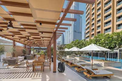 an outdoor patio with tables and chairs and umbrellas at Emaar Fashion Avenue one bedroom - Formerly Address Dubai Mall Four Apple Holiday Homes in Dubai