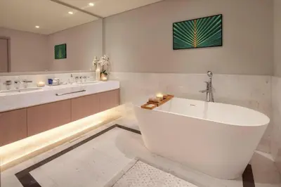 a white bathroom with a tub and a sink at HVR THE PALM DUBAI in Dubai