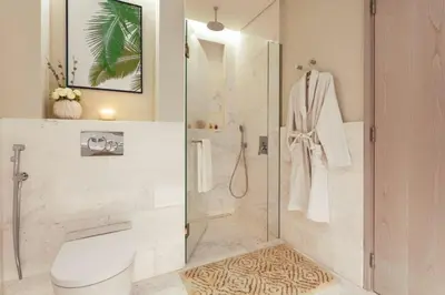 a bathroom with a shower with a toilet and a sink at HVR THE PALM DUBAI in Dubai