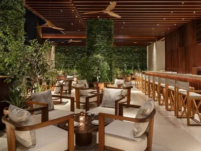 a restaurant with tables and chairs and plants at The Dubai EDITION in Dubai