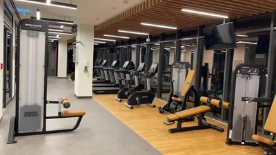 a gym with rows of treadmills and machines at Elite Inn: Parkridge904 in Dubai