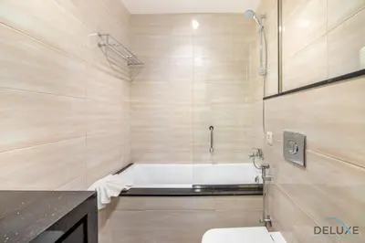 a bathroom with a bath tub and a sink at Immaculate Studio at DAMAC Celestia by Deluxe Holiday Homes in Dubai