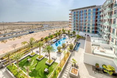 an aerial view of a resort with a pool and a beach at Immaculate Studio at DAMAC Celestia by Deluxe Holiday Homes in Dubai