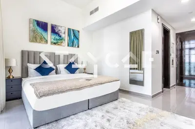 a bedroom with a large bed with blue pillows at Staycae Holiday Homes - Merano in Dubai