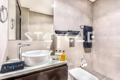 a bathroom with a sink and a toilet and a mirror at Staycae Holiday Homes - Merano in Dubai