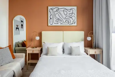 a bedroom with a white bed and a couch at Silkhaus renovated studio with Burj Khalifa view in DIFC in Dubai