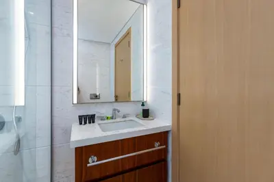 a bathroom with a sink and a mirror and a shower at Modern 1BR Apartment, High Floor, Near Dubai Mall in Dubai
