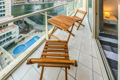 a wooden chair sitting on top of a balcony at Great views from New apartment in Dubai Marina in Dubai