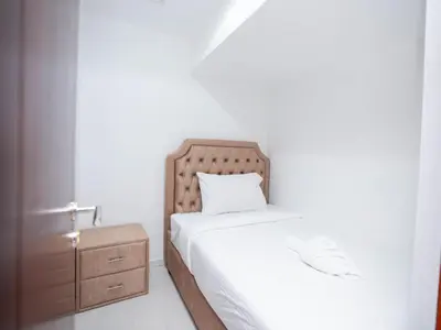 a white bedroom with a bed and a nightstand at Holidays R Us villa 3 bedroom premium location in Dubai