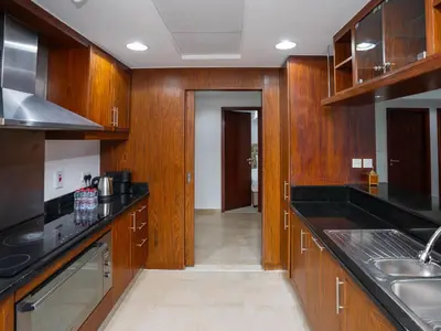 a kitchen with wooden cabinets and black counter tops at Holidays R Us villa 3 bedroom premium location in Dubai