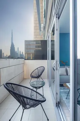 a balcony with two chairs and a couch on a building at Silkhaus elegant studio with Burj Khalifa view and balcony in Dubai